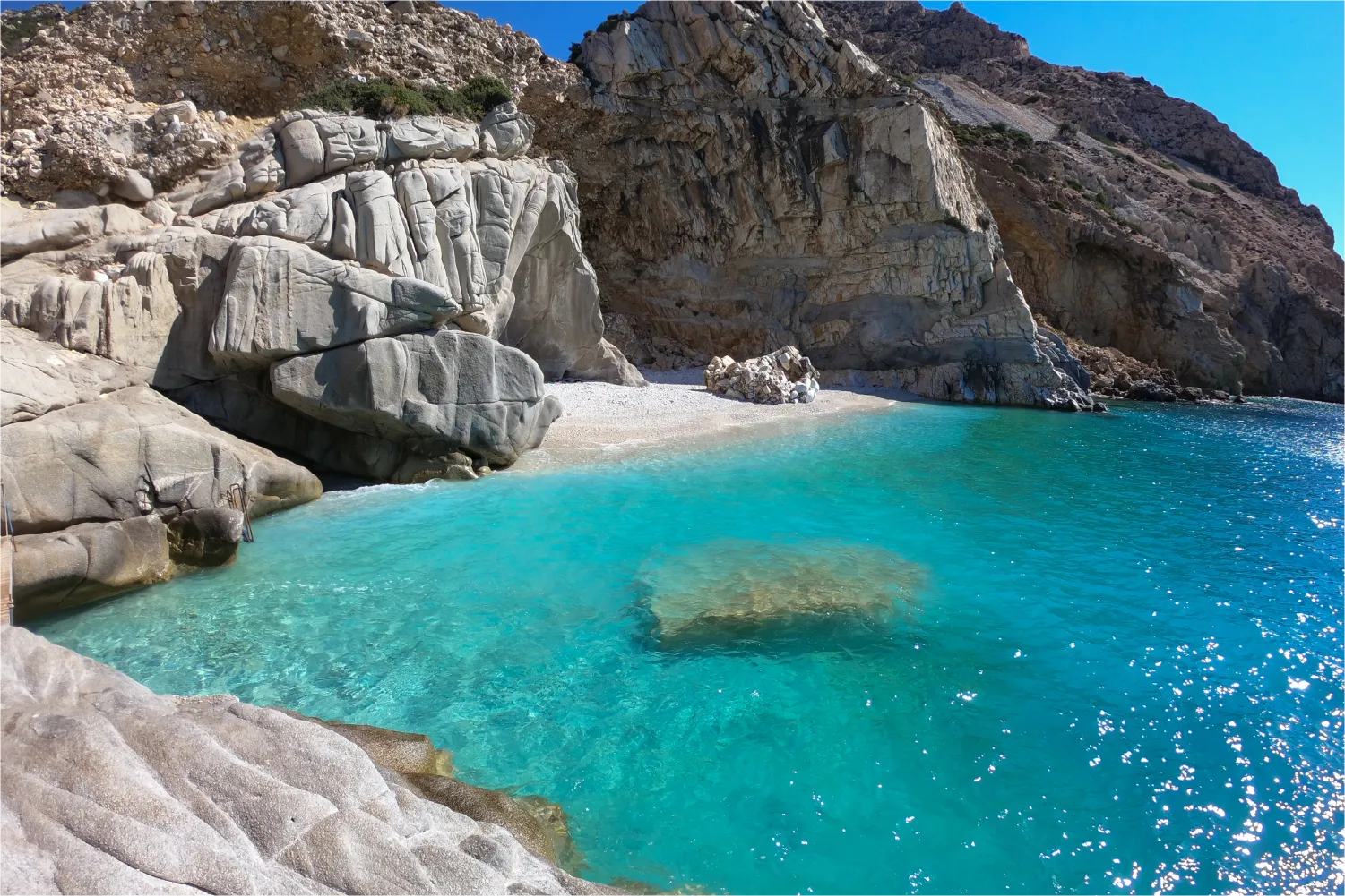 Die felsige Bucht von Seychellen Strand in Ikaria mit seinem kristallklaren Wasser