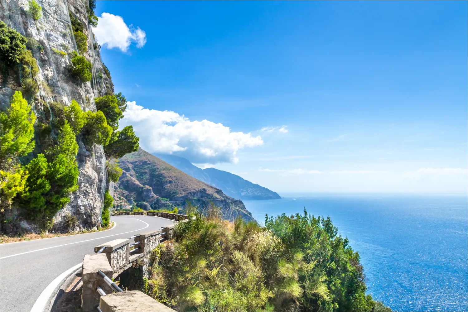 Malerische Straße entlang der Amalfiküste mit Bergen auf der einen Seite und dem Meer auf der anderen