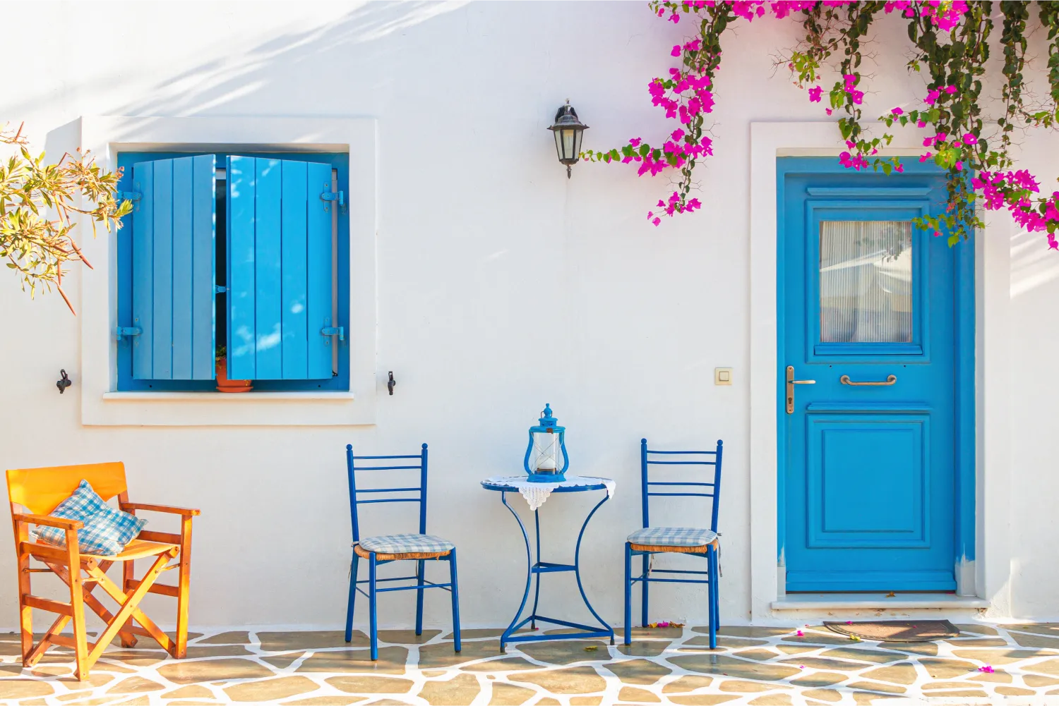 3 Stühle und ein Tisch vor einem traditionellen Haus in Antiparos