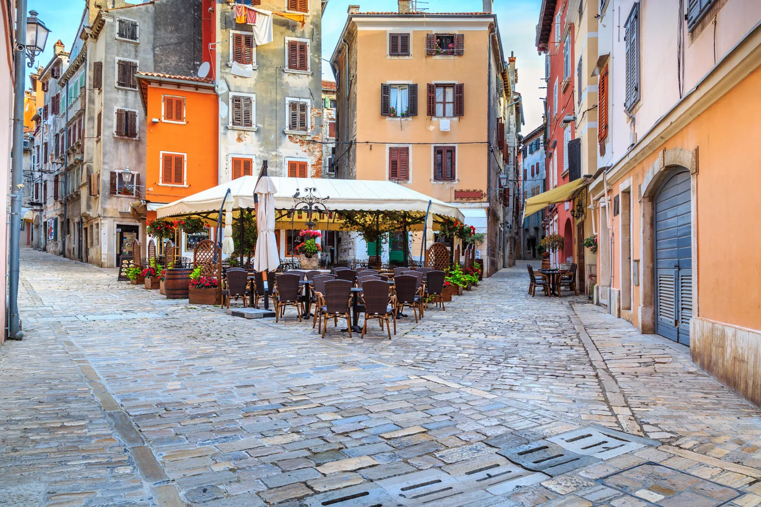 Eine gepflasterte Straße mit farbenfrohen Gebäuden und Cafés im Zentrum von Rovinj
