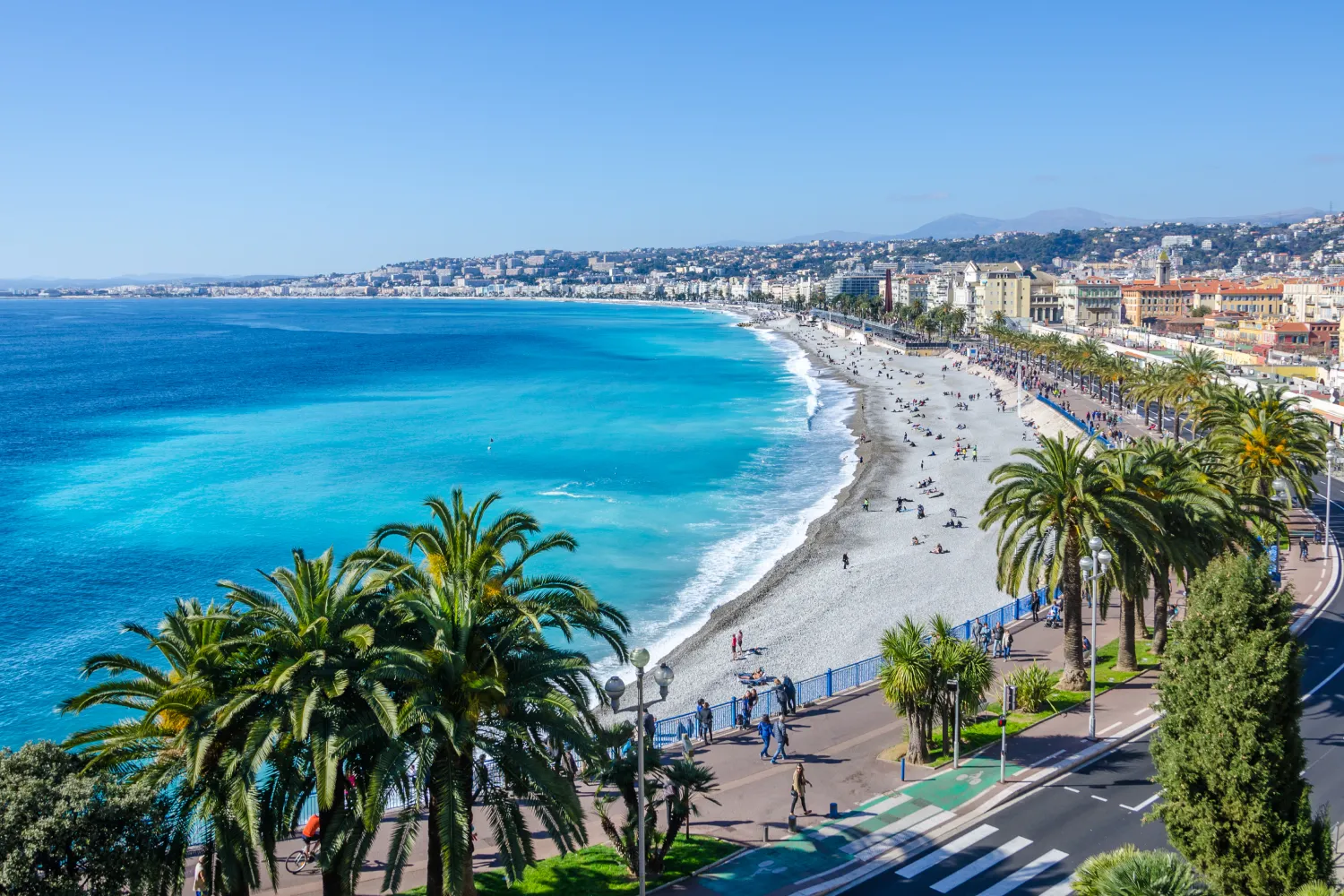Luftaufnahme der Bucht der Engel in Nizza. Pinien und Menschen, die am Ufer spazieren gehen und sich sonnen