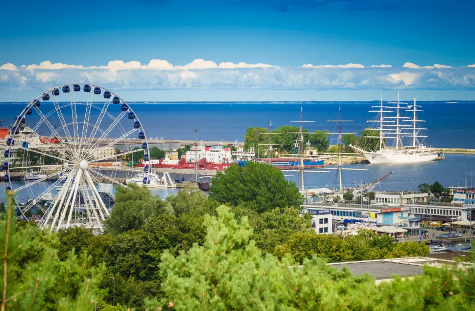 Bäume, ein Riesenrad und der Fährhafen von Gdynia, Polen