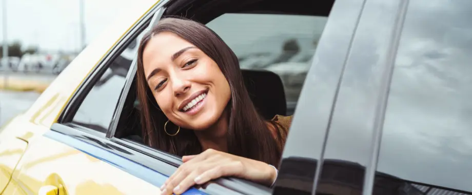 glückliche Frau schaut aus dem Fenster des Taxis