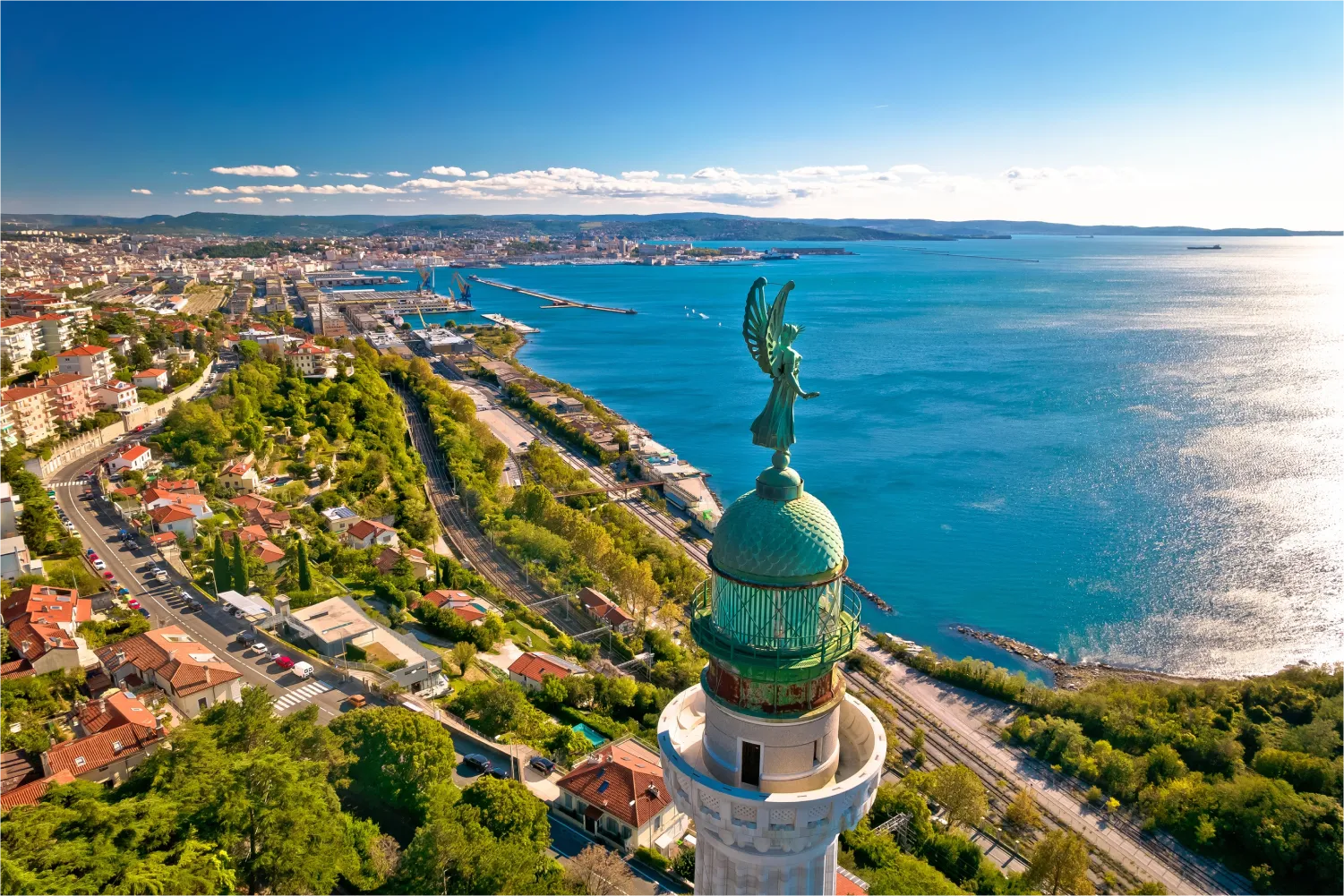 Luftaufnahme des Leuchtturms Phare De La Victoire und der Stadt Trieste im Hintergrund