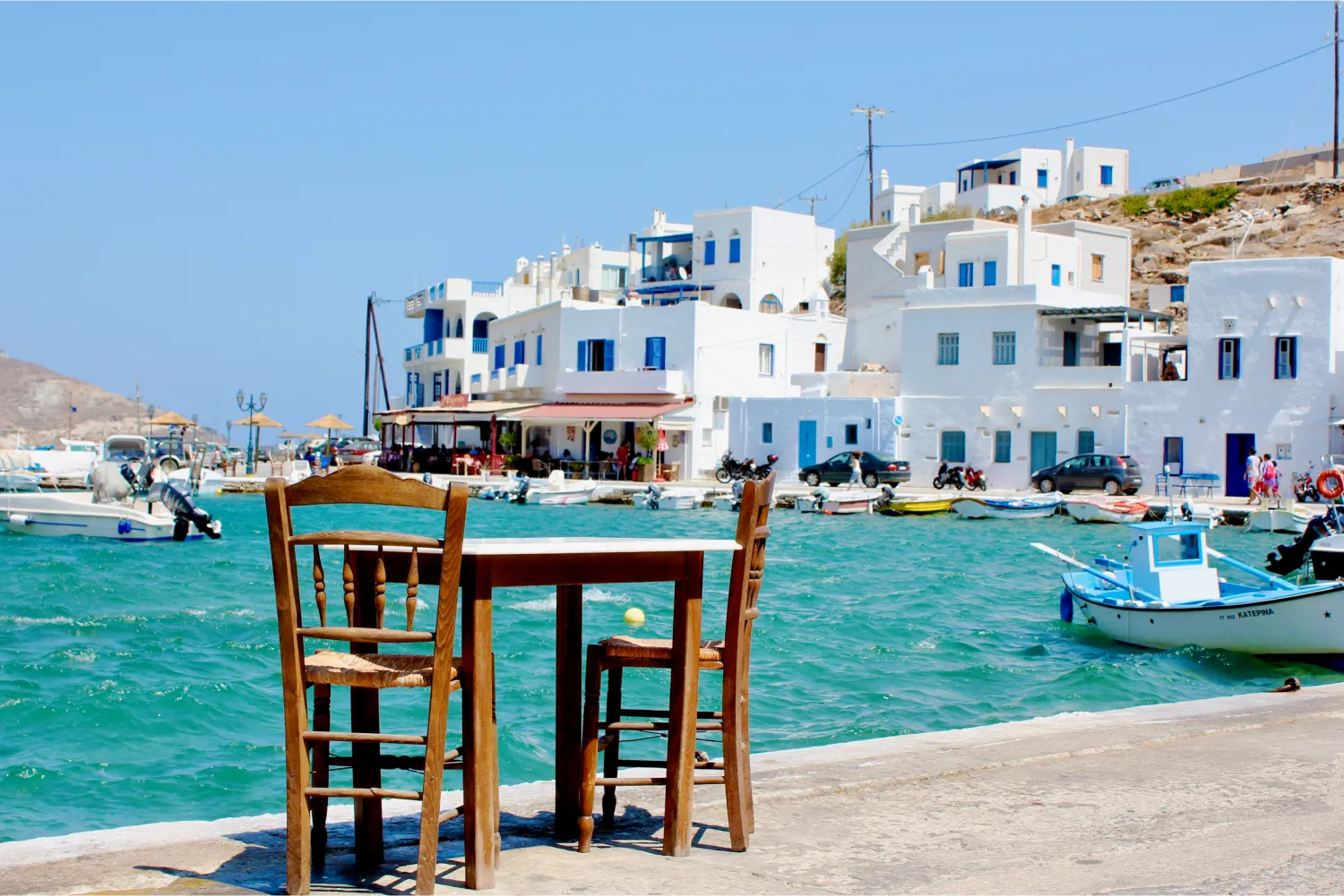 Ein Tisch für zwei Personen an einem malerischen Hafen in Tinos